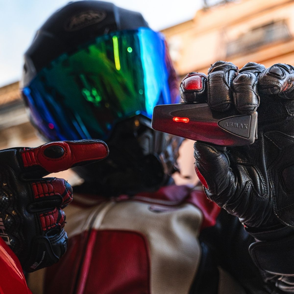 ASMAX F1 mesh intercom held by gloved motorcycle rider hand