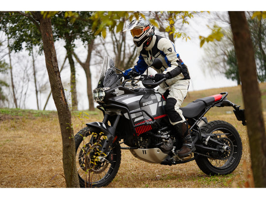  Rider standing next to a adventure motorcycle on a forest trail blog cover
