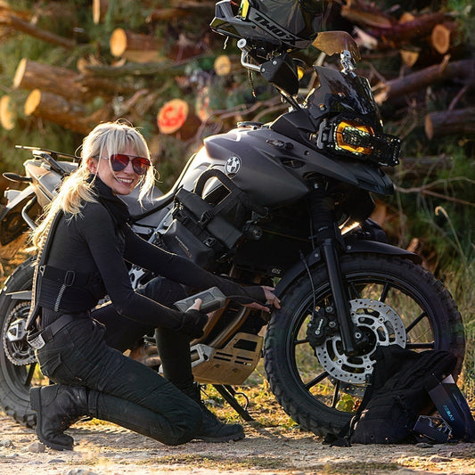 Female motorcyclist kneeling to use an ASMAX air pump on her BMW GS motorcycle blog cover