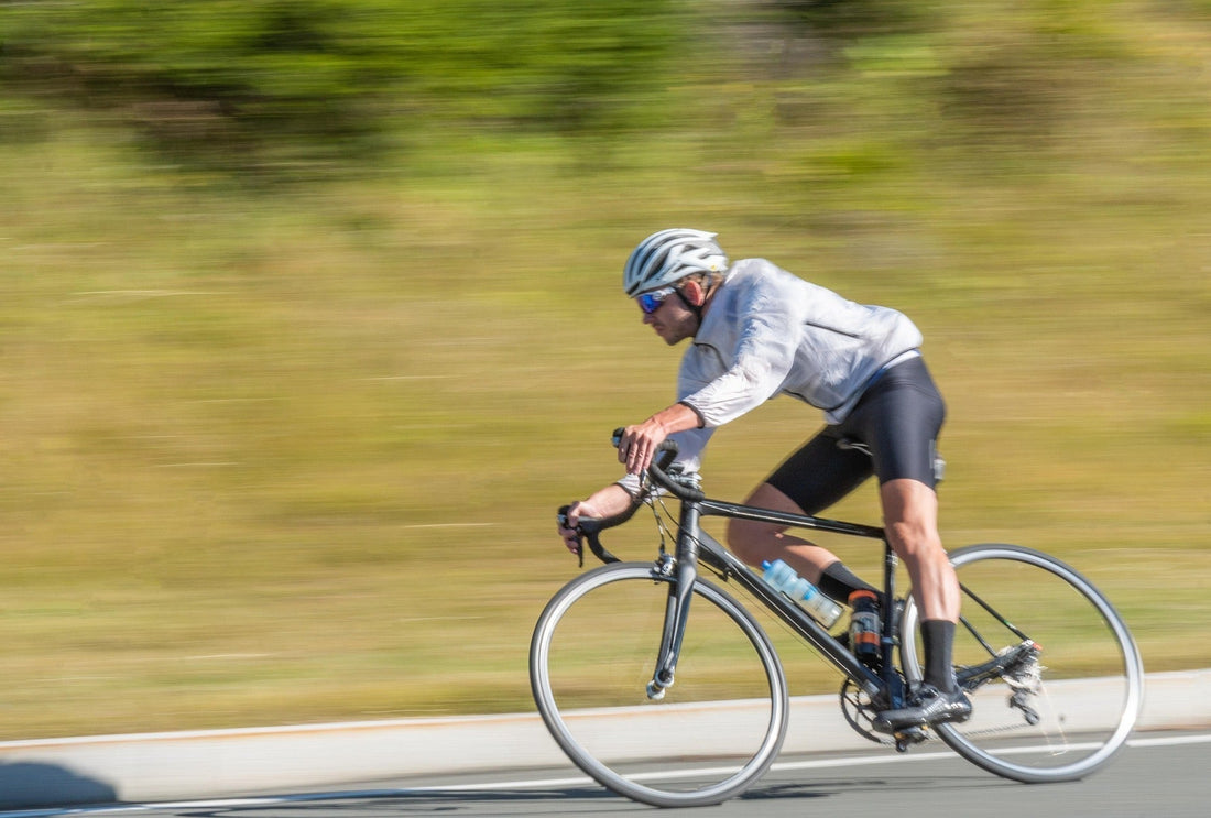 High-speed road cyclist riding with motion blur background on an asphalt road blog cover